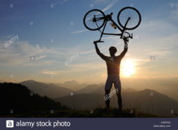 man-holding-a-racing-bike-above-his-head-into-the-air-kraftalm-alp-CXRFXG.jpg